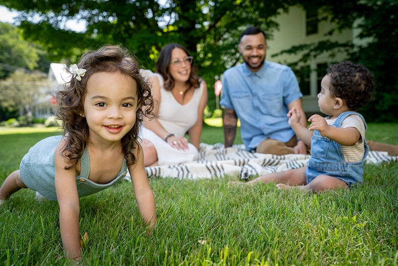 Two parents and two kids on a blanket in the grass