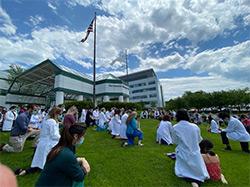People kneeling outdoors in front of Dartmouth-Hitchcock Medical Center
