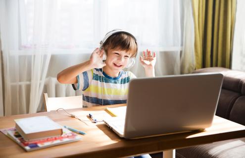 Young boy waving to a computer screen